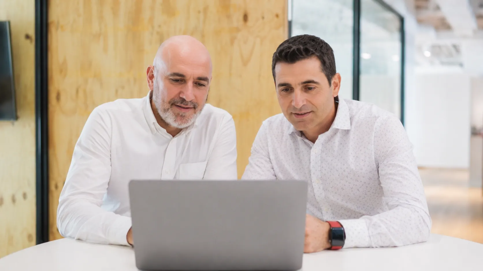Roberto Cruz and David Rey, Tietai's co-founders, working together at a laptop